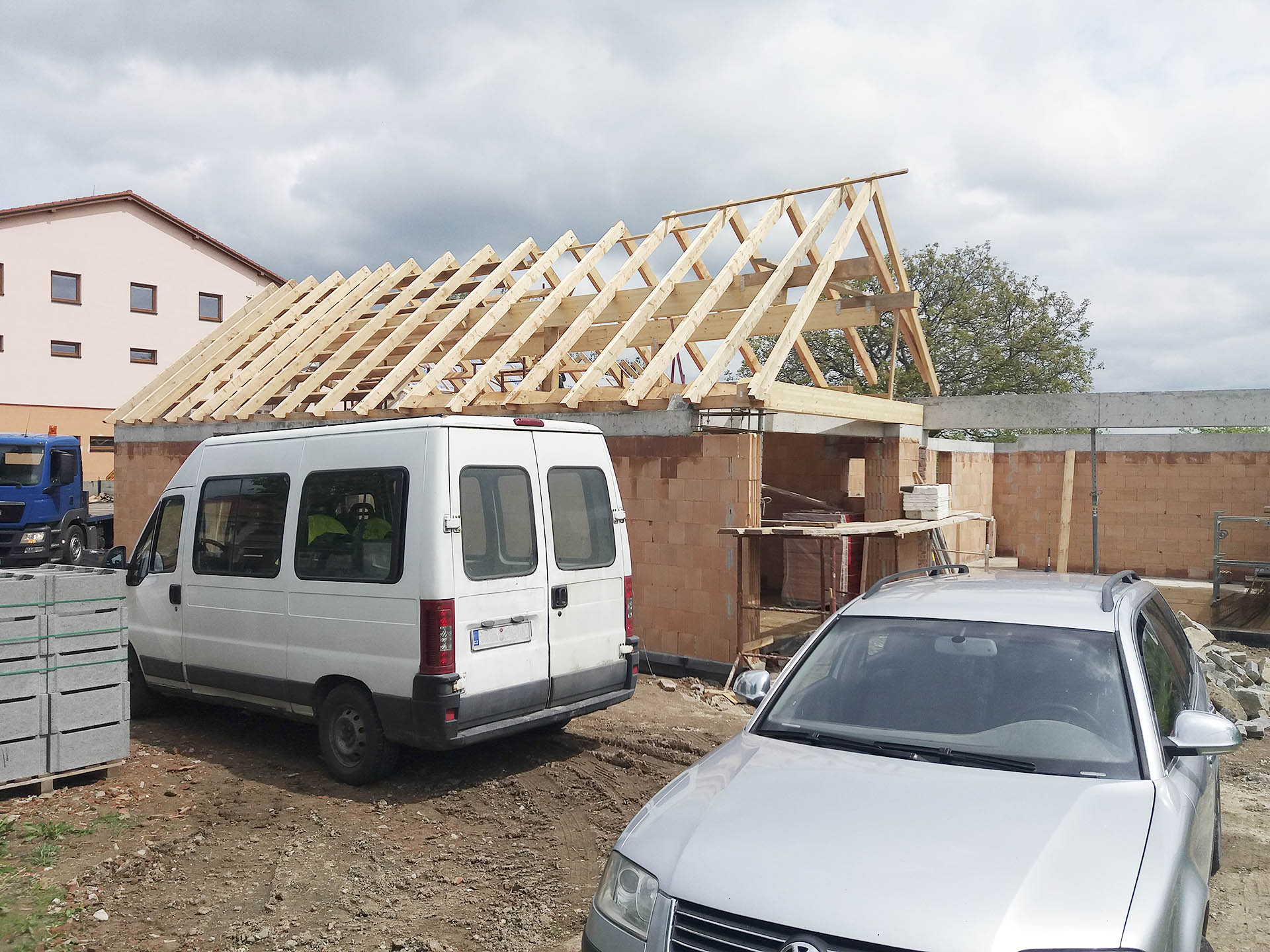 Stavba konstrukce krovu s lepenými vazníky při pohledu z ulice