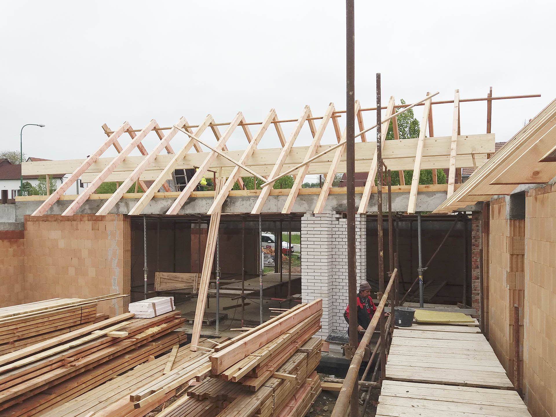 Stavba konstrukce krovu s lepenými vazníky nad otvorem pro okno s HS portálem